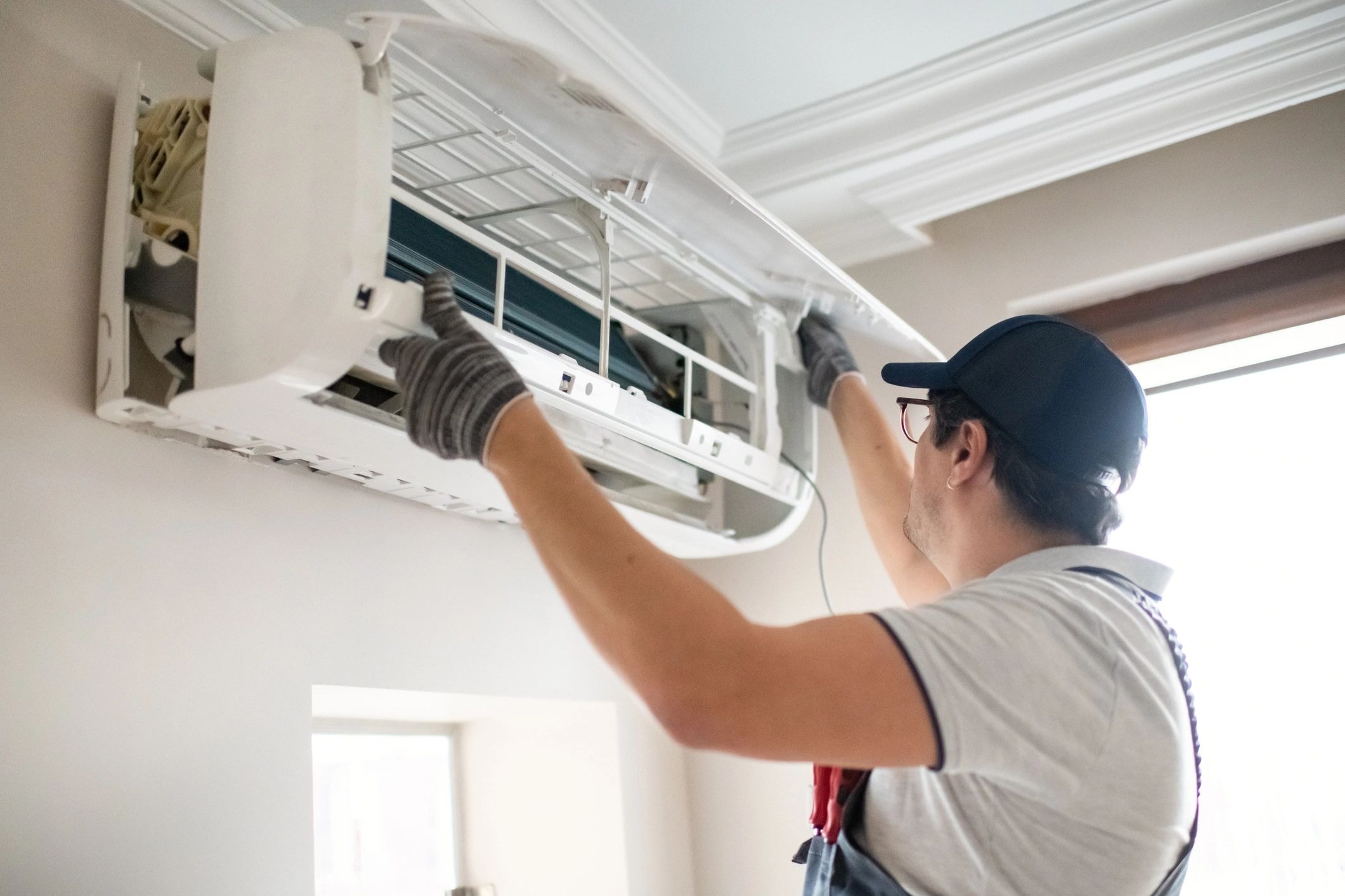 HVAC technician working on outdoor AC condenser unit